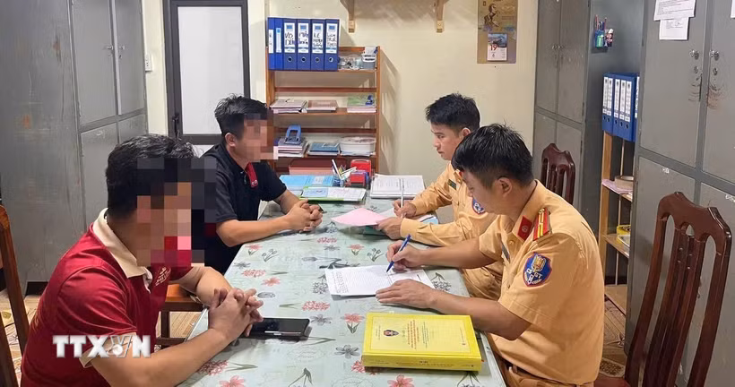 Hai tài xế xe khách làm việc với cảnh sát giao thông (Công an tỉnh Tuyên Quang). (Ảnh: TTXVN phát)