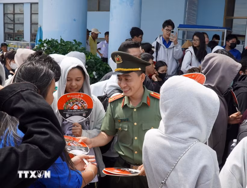 Ban Thanh niên Công an tỉnh An Giang tặng quạt tuyên truyền phòng chống ma túy đến các học sinh. (Ảnh: Văn Sĩ/TTXVN)