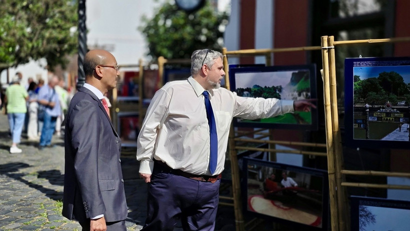 Đại sứ Việt Nam tại Hungary Bùi Lê Thái và đại diện chính quyền thủ đô Budapest xem triển lãm ảnh về đất nước, con người Việt Nam. (Ảnh: TTXVN phát)