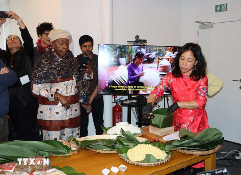 Chị Nguyễn Thị Liên, Việt kiều tại Brussels, giới thiệu cách gói bánh chưng. (Ảnh: Hương Giang/TTXVN)