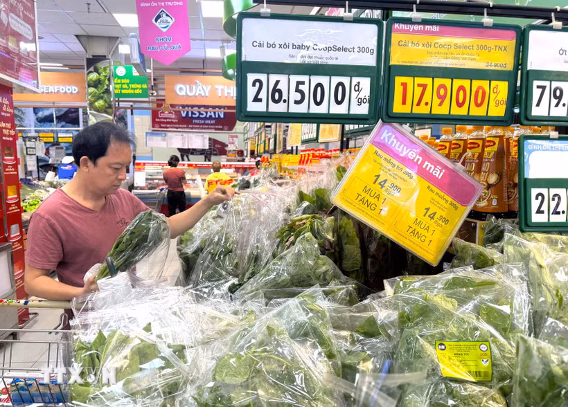 Người dân lựa chọn mua rau xanh nhãn riêng CoopSelect tại siêu thị Co.opmart trên đường Nguyễn Đình Chiểu, Thành phố Hồ Chí Minh. (Ảnh: Hương Giang/TTXVN)