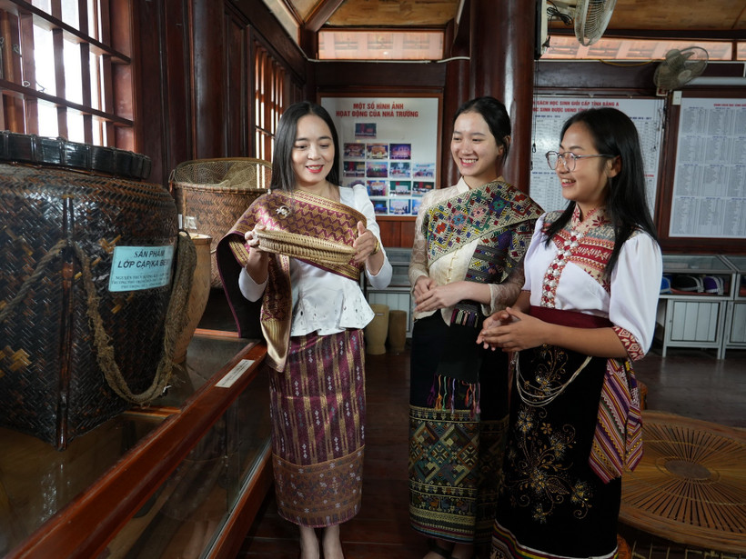 Em Bounsana Thidasavanh và các bạn tìm hiểu văn hóa truyền thống của Việt-Lào. (Ảnh: Bích Huệ/TTXVN)
