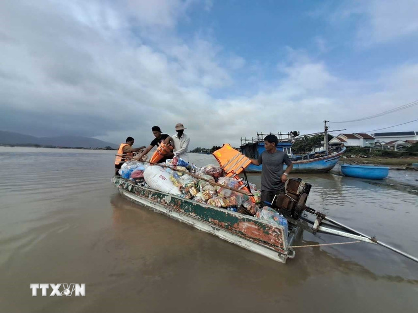 Các đoàn thiện nguyện dùng xuồng máy đi từ bến đò Phú Lạc để vào thôn Phước Giang. (Ảnh: Phạm Kha/TTXVN)