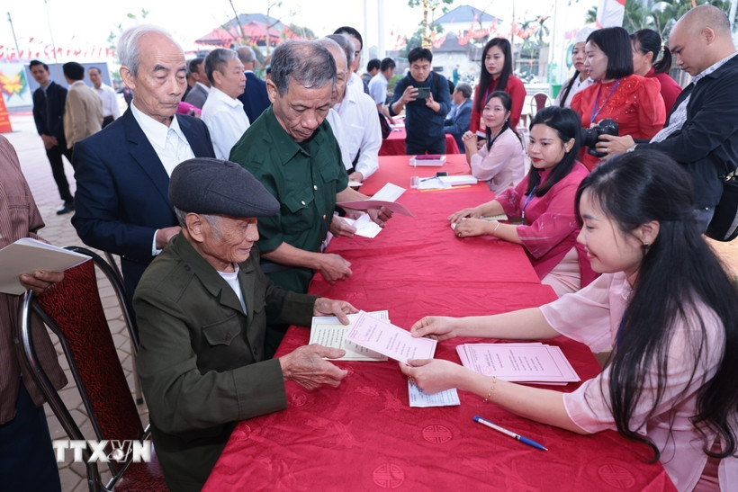 Cử tri nhận phiếu bầu cử. (Ảnh: Trần Việt/TTXVN)