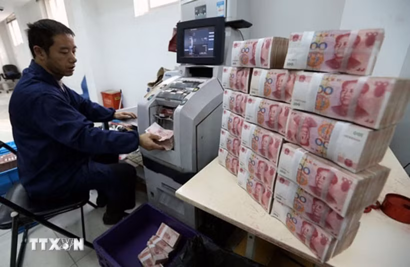 Nhân viên ngân hàng Công thương kiểm đếm đồng nhân dân tệ tại thành phố Vô Tích, tỉnh Giang Tô, Trung Quốc. (Ảnh: THX/TTXVN)
