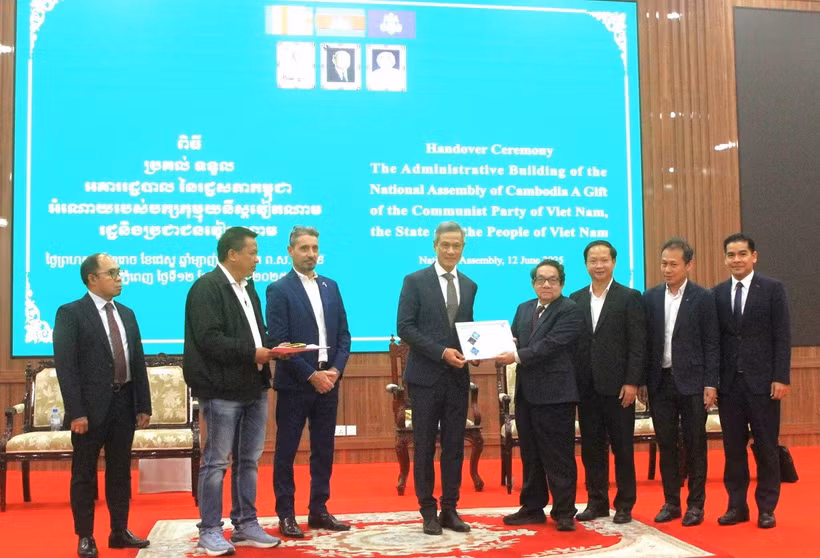 Đại sứ Việt Nam tại Campuchia Nguyễn Minh Vũ (thứ tư, từ trái sang) thực hiện nghi thức bàn giao công trình cho Tổng Thư ký Quốc hội Campuchia Leng Peng Long. (Ảnh: Hoàng Minh/TTXVN)