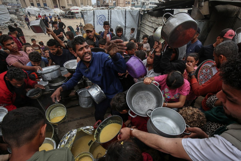 Người dân Palestine nhận thức ăn cứu trợ tại thành phố Gaza ngày 12/5/2025. (Ảnh: THX/TTXVN)