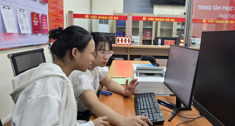 Chị Trần Thị Kim Nhung, chuyên viên phường Phù Liễn, hướng dẫn công dân gửi hồ sơ đăng ký kết hôn lên Cổng Dịch vụ công Quốc gia. (Ảnh: Minh Thu/TTXVN)