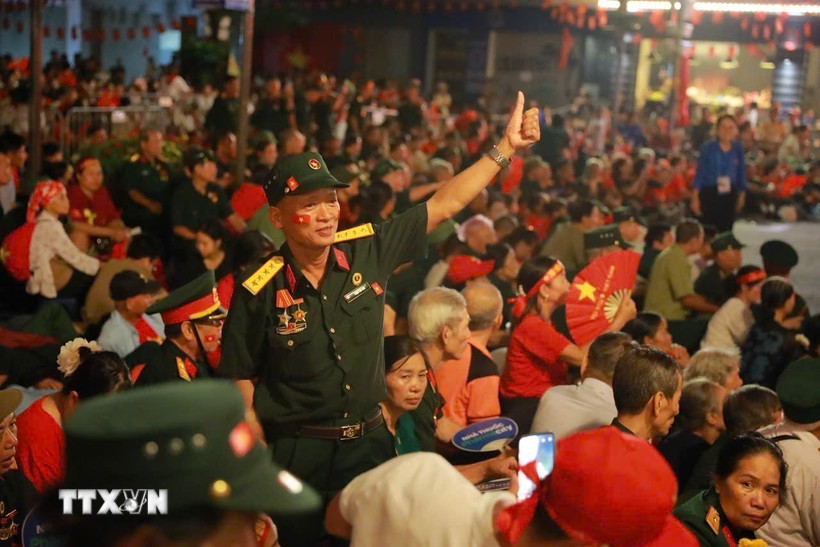 Người dân hòa trong sắc cờ đỏ, sao vàng cùng nhau chờ thời khắc Lễ diễu binh, diễu hành kỷ niệm 80 năm Quốc khánh. (Ảnh: Khánh Hòa/TTXVN)