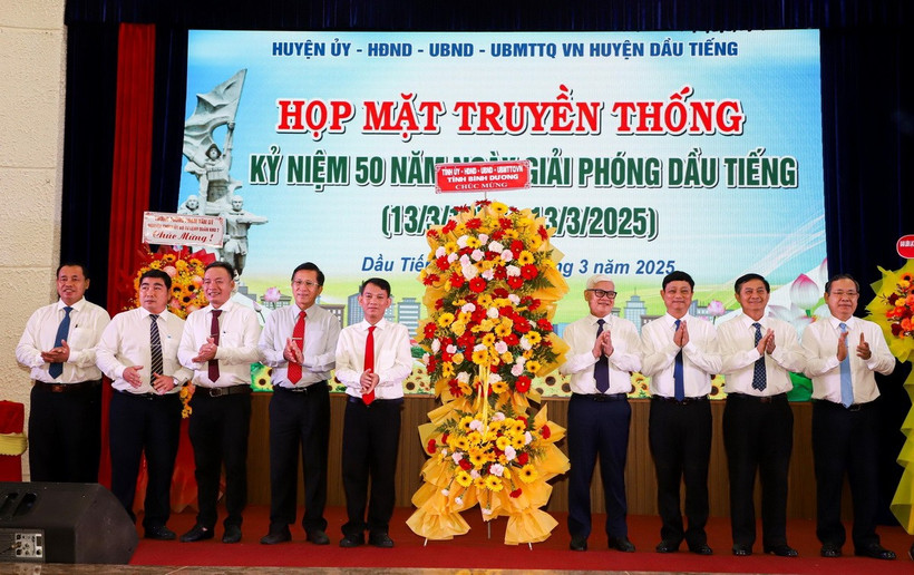 Các lãnh đạo tỉnh Bình Dương tặng hoa chúc mừng Lễ kỷ niệm 50 năm Ngày giải phóng Dầu Tiếng (13/3/1975-13/3/2025). (Ảnh: TTXVN phát)