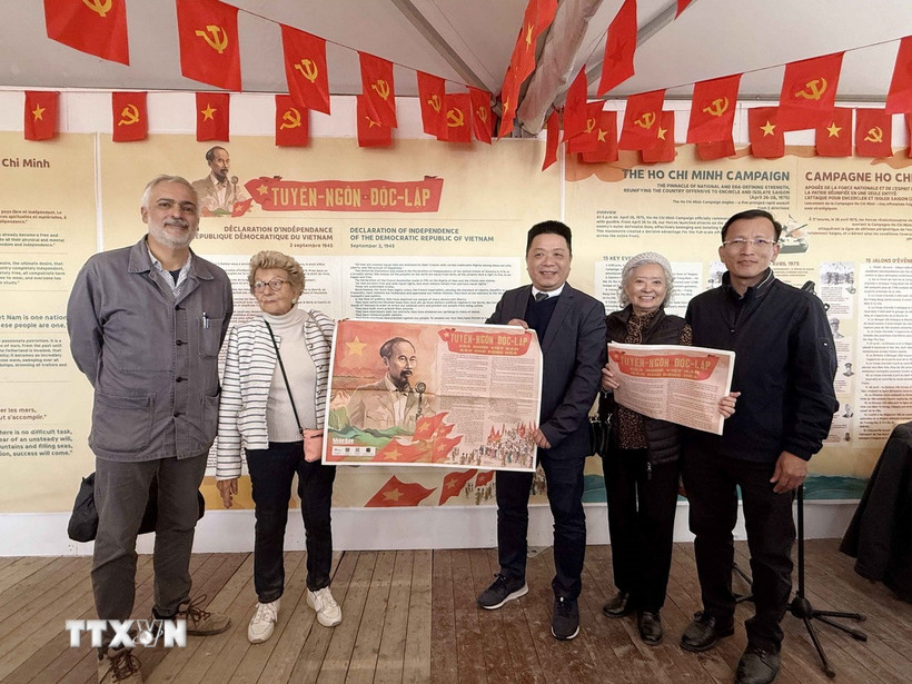 Phó Tổng biên tập Quế Đình Nguyên (giữa) trao Phụ san đặc biệt của báo Nhân Dân chào mừng 80 năm Quốc khánh Việt Nam. (Ảnh: Hữu Chiến/TTXVN)