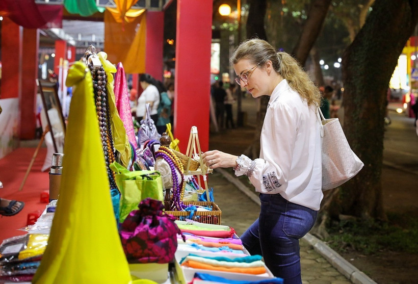 Du khách nước ngoài tham quan các sản phẩm tại gian trưng bày của làng lụa Vạn Phúc. (Ảnh: Khánh Hòa/TTXVN)