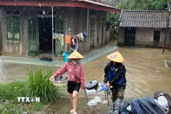 Người dân sơ tán vật dụng lên cao để tránh lũ. (Ảnh: Hoa Mai/TTXVN)