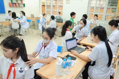 Bác sỹ bệnh viện đa khoa Xanh Pôn khám cho học sinh. (Ảnh: TTXVN)