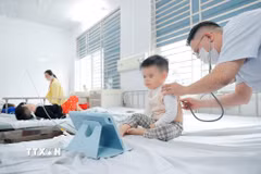 Bác sỹ khám cho bệnh nhi mắc cúm A đang điều trị tại Bệnh viện Bệnh nhiệt đới Trung ương. (Ảnh: TTXVN)