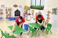 Giáo viên trường mầm non vệ sinh khu vực vui chơi để phòng tránh bệnh tay chân miệng. (Ảnh: TTXVN)