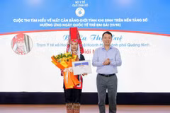 Ông Lê Thanh Dũng - Cục trưởng Cục Dân số trao Giải Nhất cá nhân cho bà La Thị Huệ - Trạm Y tế xã Hoành Mô, thành phố Quảng Ninh (Ảnh: PV/Vietnam+)