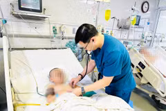 Bác sỹ theo dõi sức khỏe cho trẻ tại phòng hồi sức. (Ảnh: PV/Vietnam+)