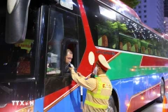 Cảnh sát giao thông kiểm tra nồng độ cồn tài xế xe khách. (Ảnh: Phạm Kiên/TTXVN)