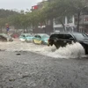 Chỉ sau vài phút mưa tuyến phố Nguyễn Văn Cừ, Long Biên đã ngập úng diện rộng gây ảnh hưởng đến các phương tiện tham gia giao thông. (Ảnh: An Đăng/TTXVN)
