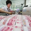 Nhân viên ngân hàng kiểm đếm đồng nhân dân tệ tại Giang Tô, Trung Quốc. (Nguồn: THX/TTXVN)