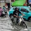 Nước ngập nửa bánh xe mô tô trên đường Tô Ngọc Vân (thành phố Thủ Đức). (Ảnh: TTXVN phát)