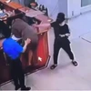 Người đàn ông chồm lên quầy làm thủ tục hành hung nhân viên bệnh viện. (Nguồn: Ảnh chụp màn hình)