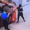 Người đàn ông chồm lên quầy làm thủ tục hành hung nhân viên bệnh viện. (Nguồn: Ảnh chụp màn hình)
