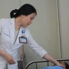 Bác sỹ Nguyễn Thị Minh Chí thăm khám bệnh nhân. (Ảnh: Văn Dũng/TTXVN)