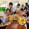 Các em học sinh Việt Nam-Lào háo hức chuẩn bị Tết Trung thu. (Ảnh: Xuân Tú/TTXVN)