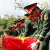 Đội tiêu binh thực hiện nghi thức an táng liệt sỹ. (Ảnh: Hồng Thái/TTXVN)