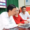 Bí thư chi bộ Thôn 3 Lộc Ngãi Hồ Thị Hồng Liên (ngồi giữa) cùng các cán bộ thôn giám sát hoạt động của thôn thông qua 12 camera lắp trên toàn thôn. (Ảnh: Chu Quốc Hùng/TTXVN)