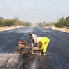 Công nhân chuẩn bị cho việc thảm nhựa mặt đường cao tốc Vạn Ninh-Cam Lộ vào dịp giáp Tết đoạn qua huyện Vĩnh Linh, tỉnh Quảng Trị. (Ảnh: Nguyên Lý/TTXVN)
