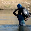 Người di cư vượt sông Rio Grande ở biên giới Mỹ-Mexico. (Ảnh: THX/TTXVN)