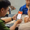 Tổ chuyển đổi số cộng đồng hướng dẫn người dân sử dụng ứng dụng VNeID. (Ảnh: Hoàng Hiếu/TTXVN)