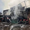 Các lực lượng chức năng dập lửa. (Ảnh: TTXVN phát)