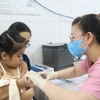 Nhân viên trạm y tế tiêm vaccine phòng sởi cho trẻ. (Ảnh: Đinh Hằng/TTXVN)