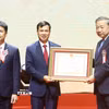 Tổng Bí thư, Chủ tịch nước Tô Lâm trao Huân chương Lao động hạng Nhất tặng Đại học Quốc gia Hà Nội. (Ảnh: Thống Nhất/TTXVN)