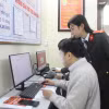 Cán bộ Công an thành phố Hà Nội hướng dẫn người dân thực hiện các thao tác giải quyết thủ tục cấp Phiếu lý lịch tư pháp. (Ảnh: Nguyễn Thắng/TTXVN)