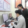 Cán bộ Công an thành phố Hà Nội hướng dẫn người dân thực hiện các thao tác giải quyết thủ tục cấp Phiếu lý lịch tư pháp. (Ảnh: Nguyễn Thắng/TTXVN)