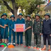 Thượng tướng Trương Thiên Tô trao quà cho các cán bộ chiến sỹ đang hỗ trợ trường Tiểu học Trần Quốc Toản tổng vệ sinh sau ngập lụt. (Ảnh: Văn Dũng/TTXVN)