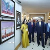 Tổng Bí thư Tô Lâm, Thủ tướng Phạm Minh Chính và các đại biểu xem trưng bày ảnh tại Lễ kỷ niệm. (Ảnh: Thống Nhất/TTXVN)