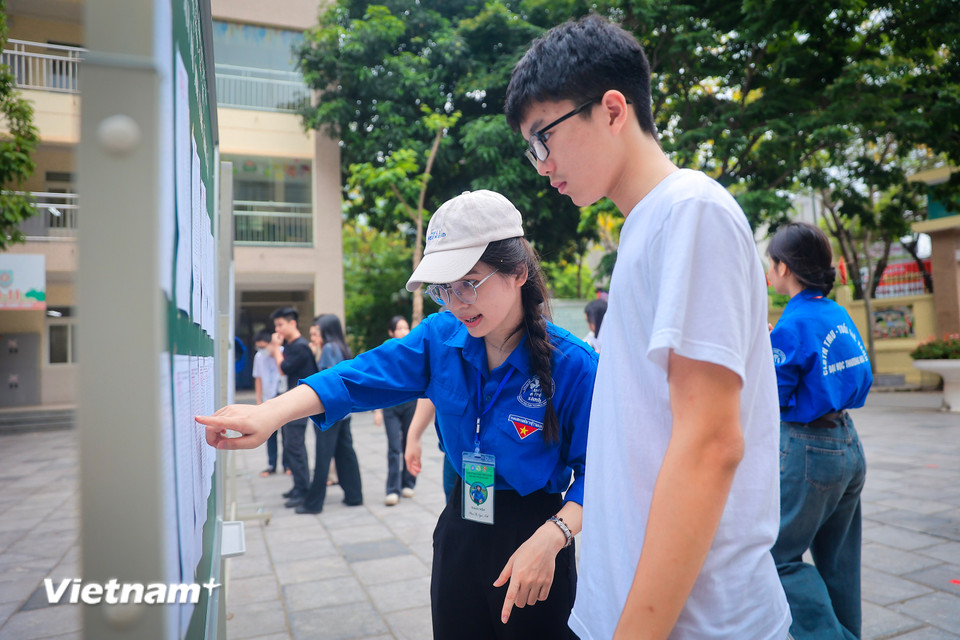 Tình nguyện viên hướng dẫn thí sinh tìm phòng thi. (Ảnh: Hoài Nam/Vietnam+)