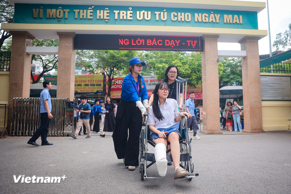 Thí sinh được hỗ trợ đưa vào điểm thi để làm thủ tục dự thi. (Ảnh: Hoài Nam/Vietnam+)