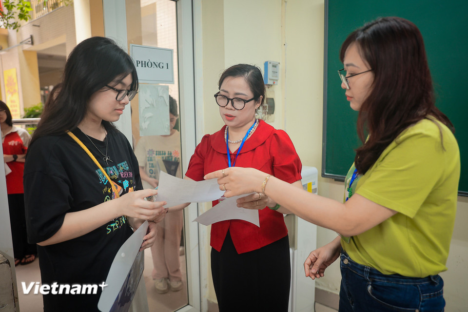 Các giám thị kiểm tra thông tin thí sinh trước khi vào phòng nghe phổ biến quy chế thi. (Ảnh: Hoài Nam/Vietnam+)