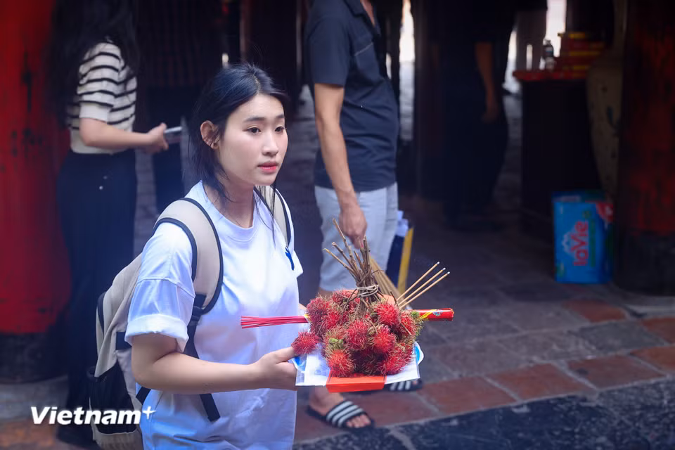 Trước kỳ thi Tốt nghiệp THPT 2025, Trần Thị Bảo Linh, học sinh trường Trung học phổ thông Ngô Sĩ Liên (Hà Nội) đã tới trường đại học đầu tiên ở Việt Nam, chuẩn bị mâm lễ quả kèm giấy báo dự thi, bút, máy tính để dâng lễ 'xin vía' đỗ đạt nguyện vọng trong kỳ thi sắp tới. (Ảnh: Hoài Nam/Vietnam+)