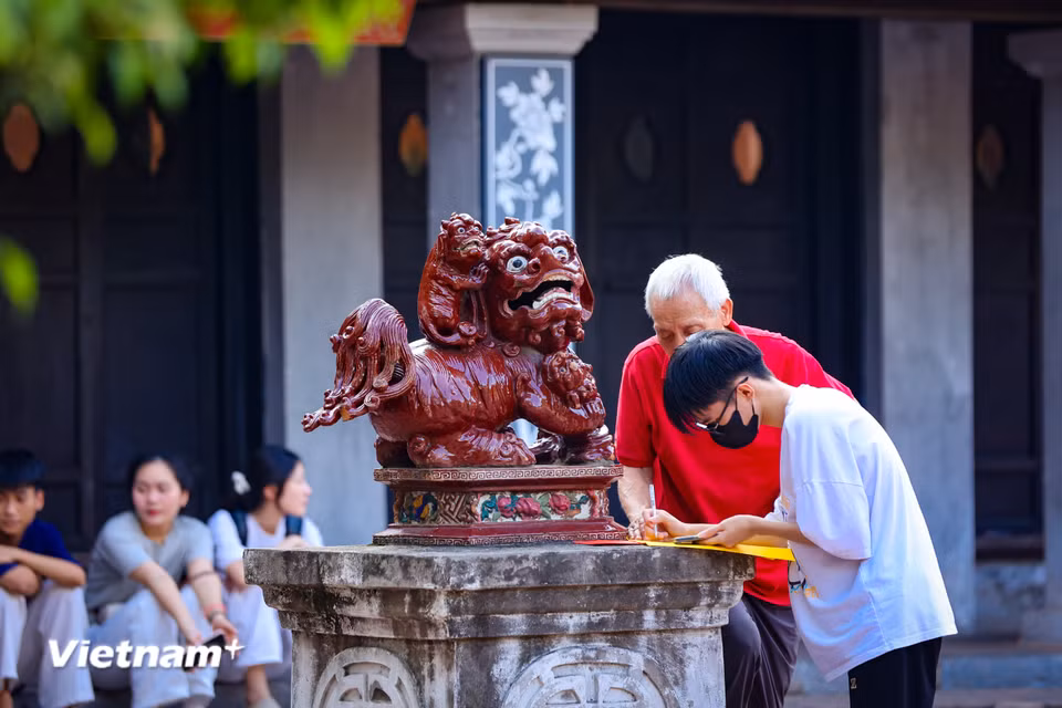 Nhiều phụ huynh cho rằng kết quả phụ thuộc vào năng lực của các con, việc đi Văn Miếu cầu khấn chỉ là một cách giải tỏa tâm lý cho các con trước kỳ thi này. (Ảnh: Hoài Nam/Vietnam+)