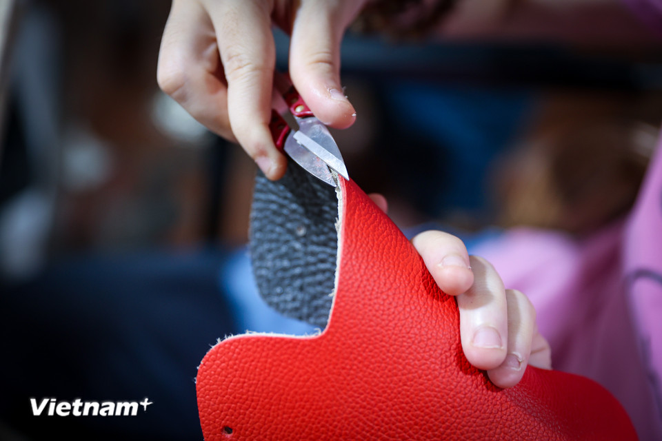 Mỗi đường cắt, mũi chỉ, mỗi ngôi sao vàng được in lên nền da đỏ không chỉ là công đoạn kỹ thuật, mà còn là cách họ gửi gắm lòng tự hào dân tộc. (Ảnh: Hoài Nam/Vietnam+)