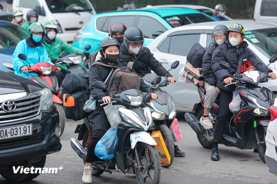 Người dân lỉnh kỉnh chằng đồ đạc trở về quê nghỉ Tết Âm lịch. (Ảnh: Hoài Nam/Vietnam+)