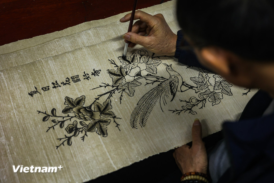 Những chất liệu dân gian cùng hình ảnh quen thuộc hằng ngày vẫn hiện mình lên tờ giấy dó dưới bàn tay và trái tim nhiệt huyết với nghề. (Ảnh: Hoài Nam/Vietnam+)